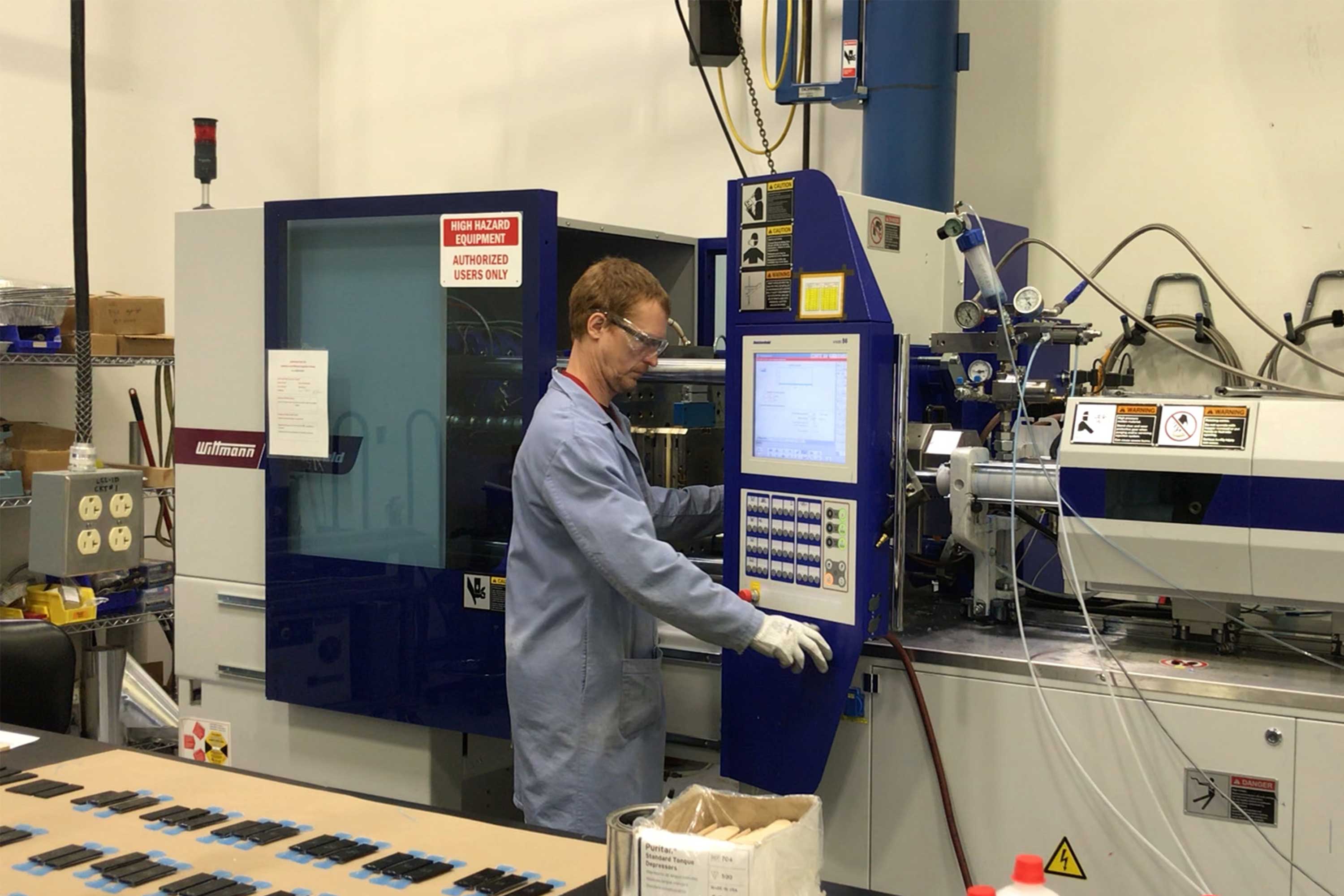 person looking at injection molding machine