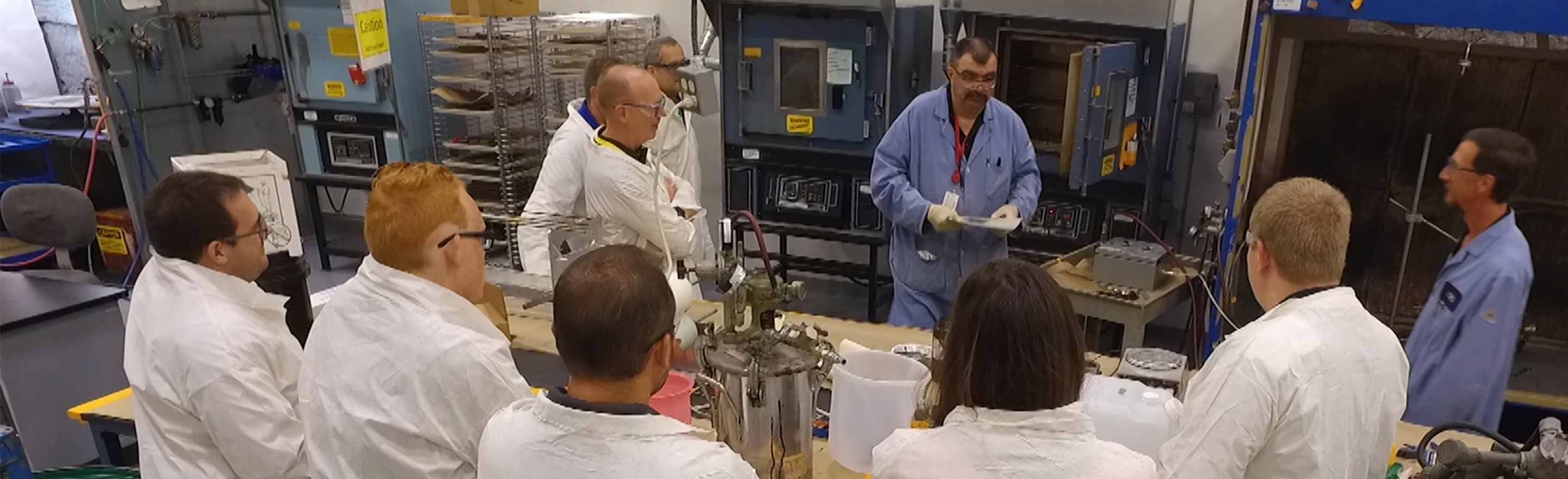 LORD academy training with attendees in lab coats watching demonstrations in the lab.