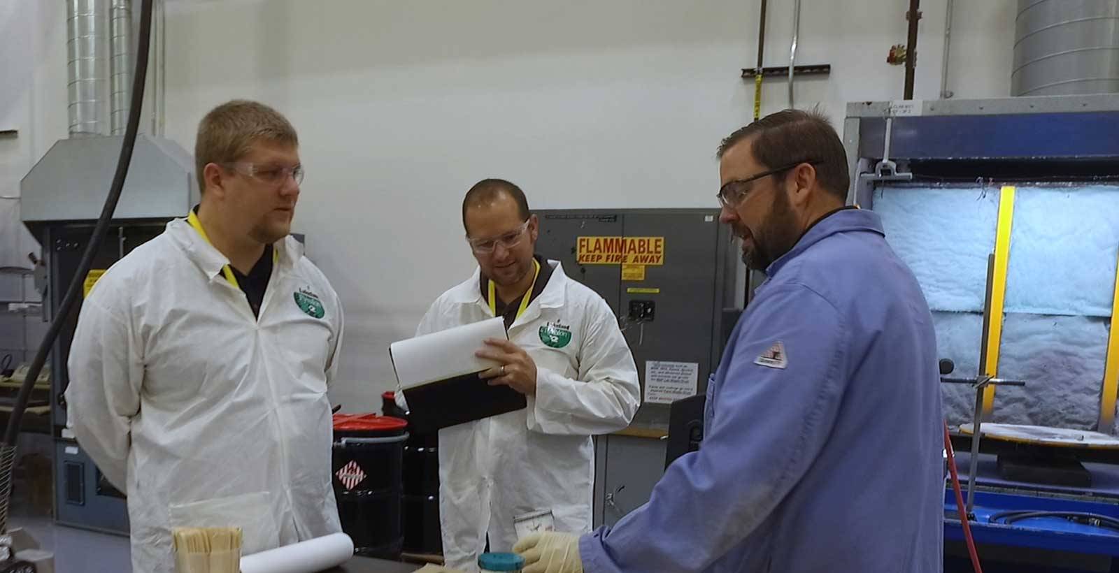 Scientist talking to two people in the lab learning about Chemlok Adhesives